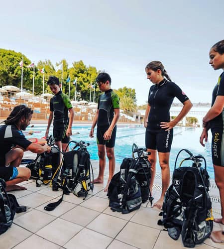 Gruppo di subacquei con attrezzatura pronta per immersione in piscina.