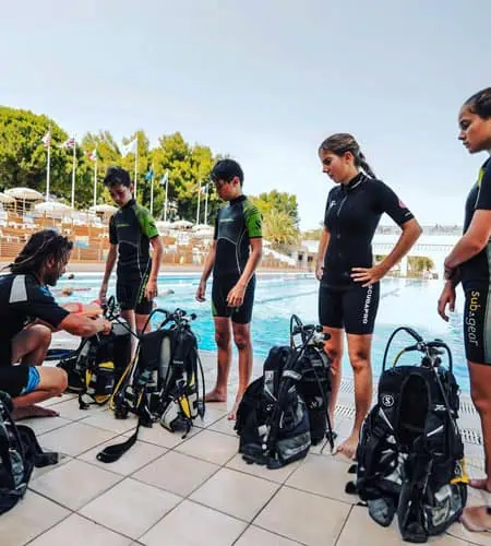 Tauchergruppe mit Ausrüstung im Pool.