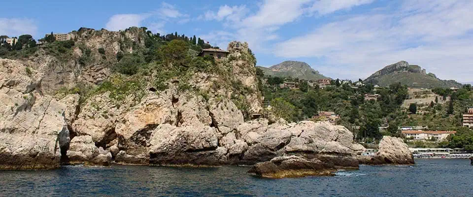 Vista mare dell'Isola Bella Nord con scogli e vegetazione rigogliosa.