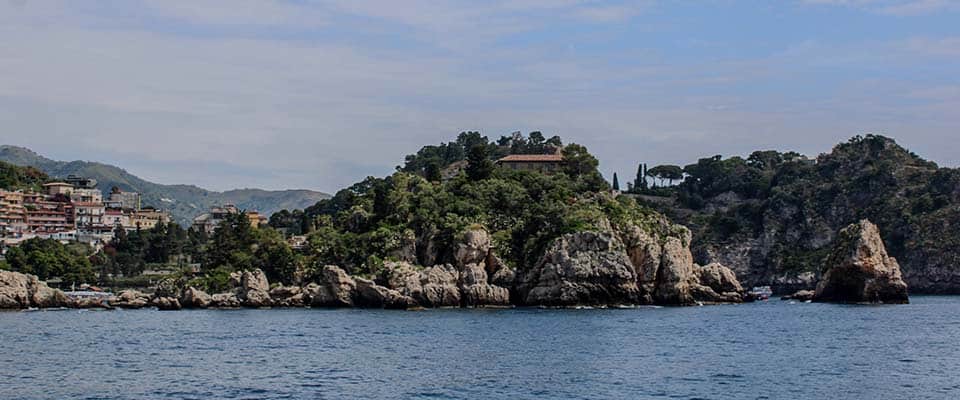Isola Bella Sud vista dal mare con scogli e vegetazione rigogliosa.