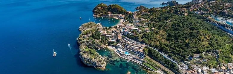Spiaggia e scogliera a Baia Atlantis, zona di mare cristallino e natura incontaminata.
