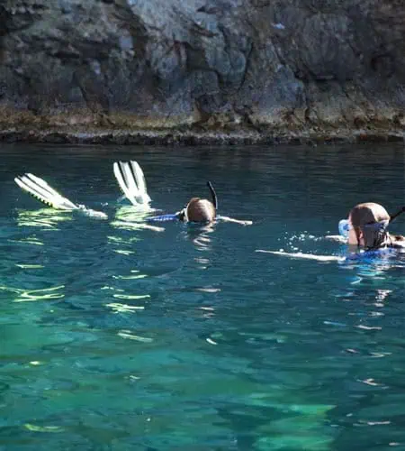 Immersione e snorkeling in acque limpide con esploratori subacquei.