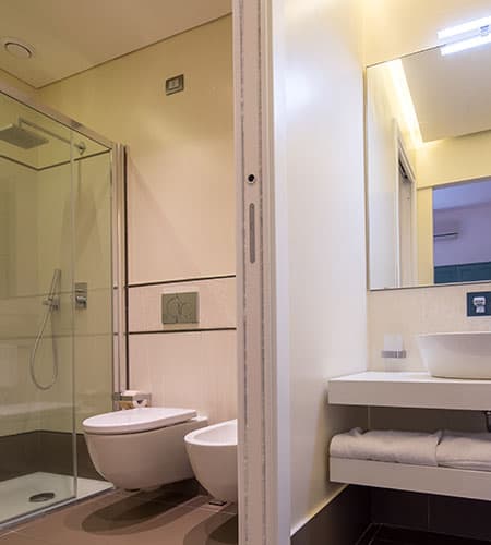 Bagno con doccia, WC e lavabo in stile moderno, ambiente luminoso e pulito, arredamento minimalista,.