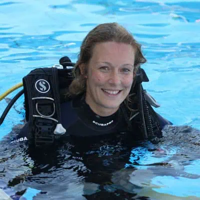 Immersione subacquea con attrezzatura professionale e formazione esperta in acque cristalline.