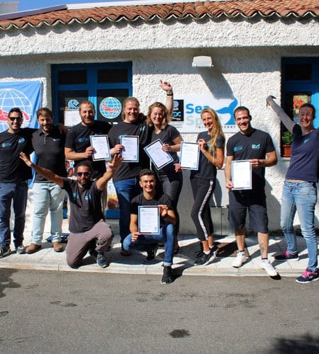 Gruppo di persone felici con certificati davanti all'ufficio Sea Spirit.