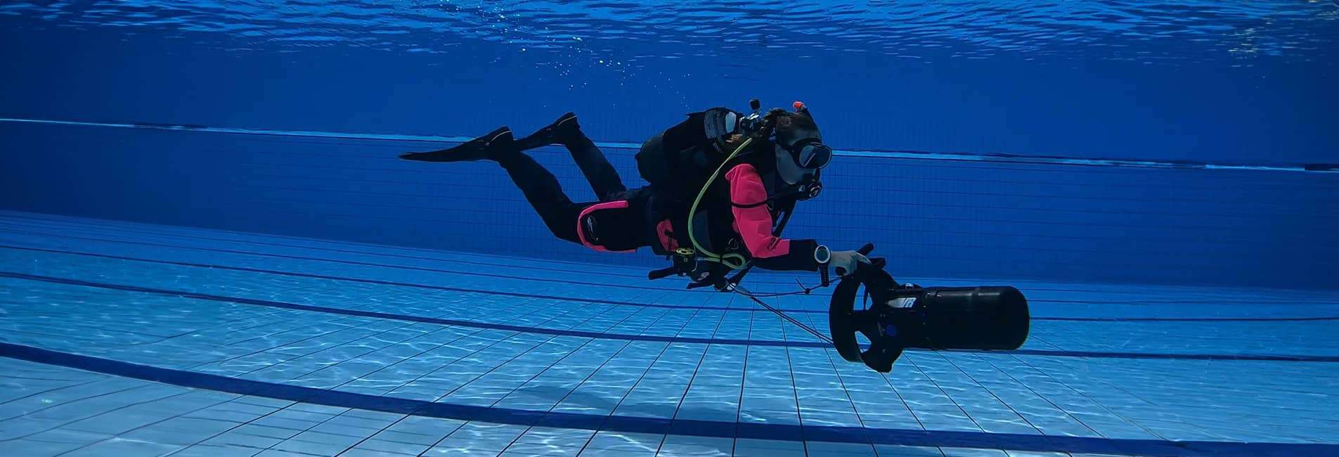 Subacqueo con veicolo di propulsione Padi Diver DPV in piscina.