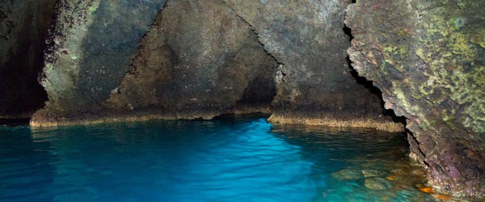 Spiaggia con acque cristalline e scogliere nella Grotta Azzurra.