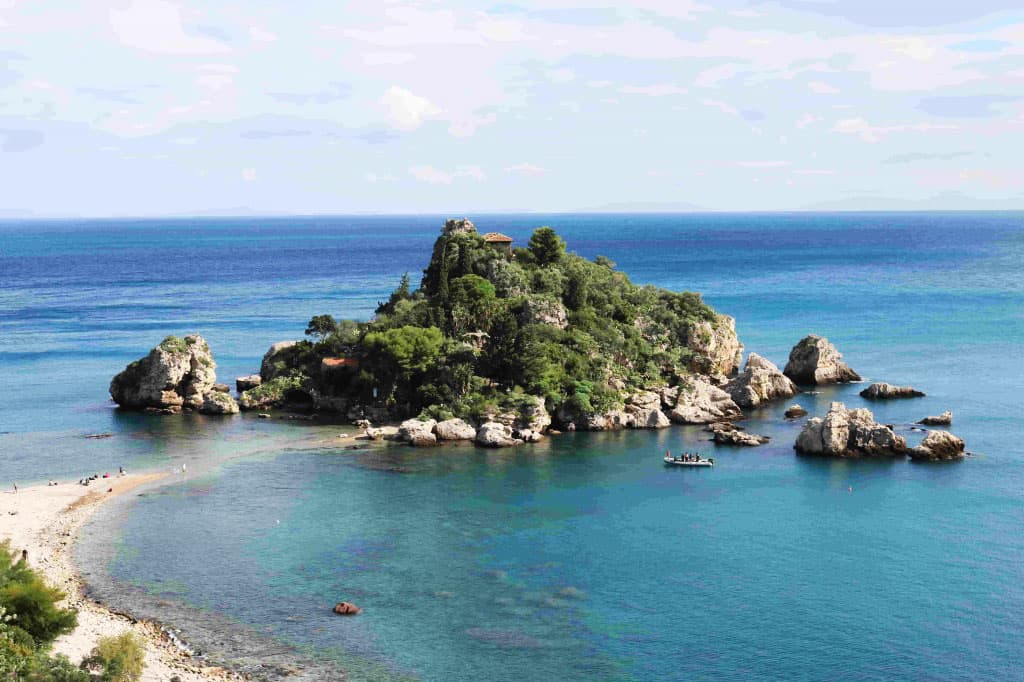 Immagine di un'isola rocciosa circondata dal mare cristallino di Taormina, perfetta per immersioni P.