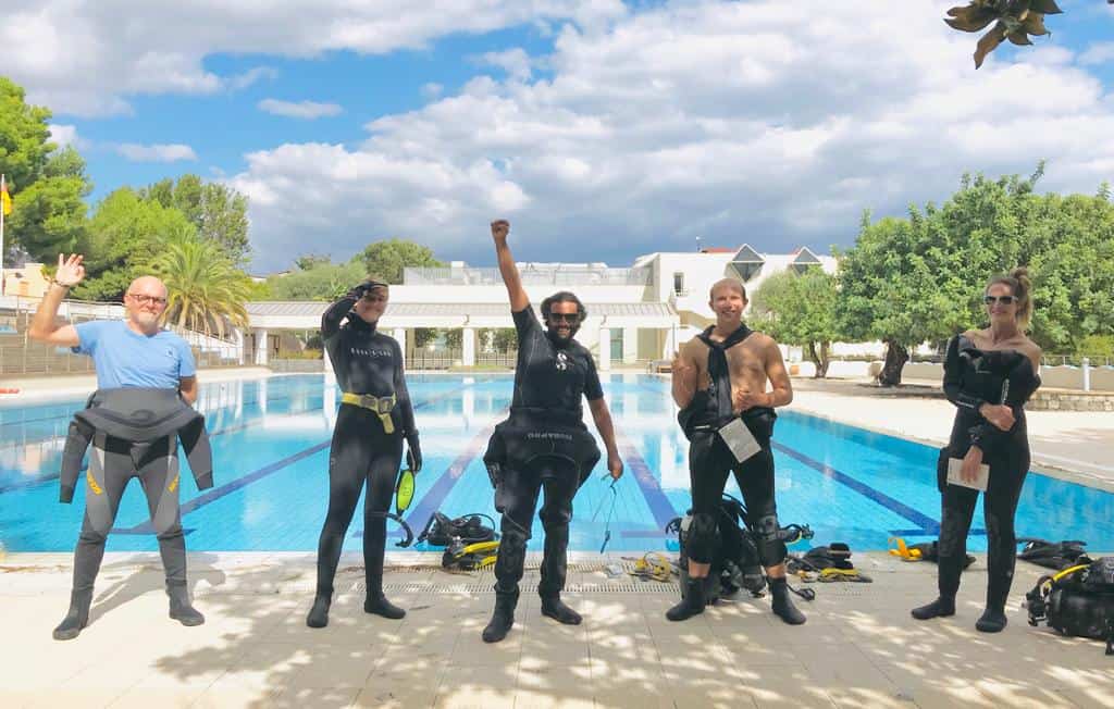 Immagine di un gruppo di subacquei felici davanti alla piscina, pronti per immersioni a Taormina, Si.