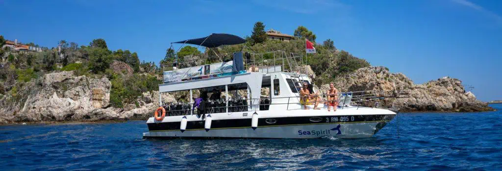 Snorkeling a Taormina: le escursioni più amate 3 Barca Sea Spirit naviga nelle acque cristalline con persone a bordo, godendo di un'esperienza di cro.